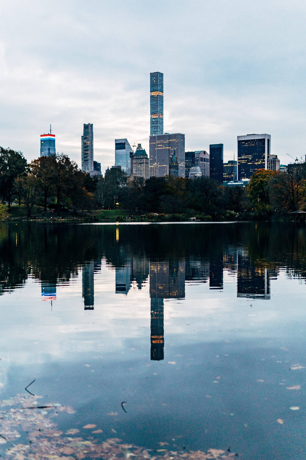 中央公園湖泊倒映曼哈頓天際線與秋樹