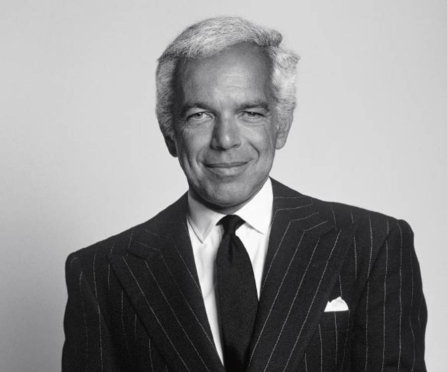 中年時期的 Ralph Lauren 壁紙 — 一位微笑的老年男士穿著細條紋西裝，在素色背景前的黑白肖像。