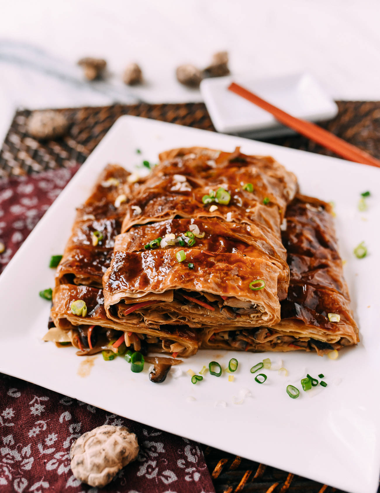 淋上深色醬汁並以青蔥裝飾的鹹味蔬菜卷。