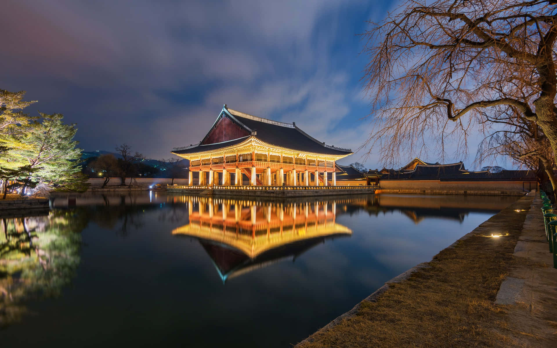 夜晚平靜水面上反射的燈火通明的傳統宮殿。