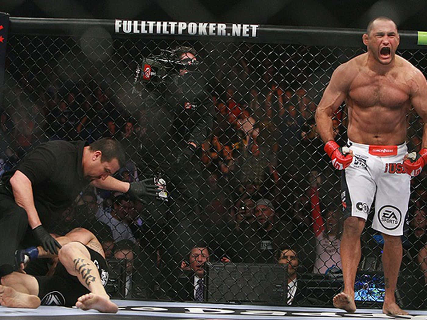 MMA拳手在八角籠中慶祝勝利，對手正由裁判檢查。