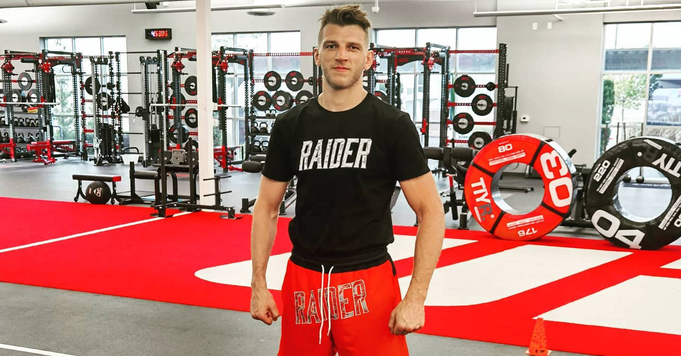 健身房的運動型男子穿著 'RAIDER' 襯衫和短褲