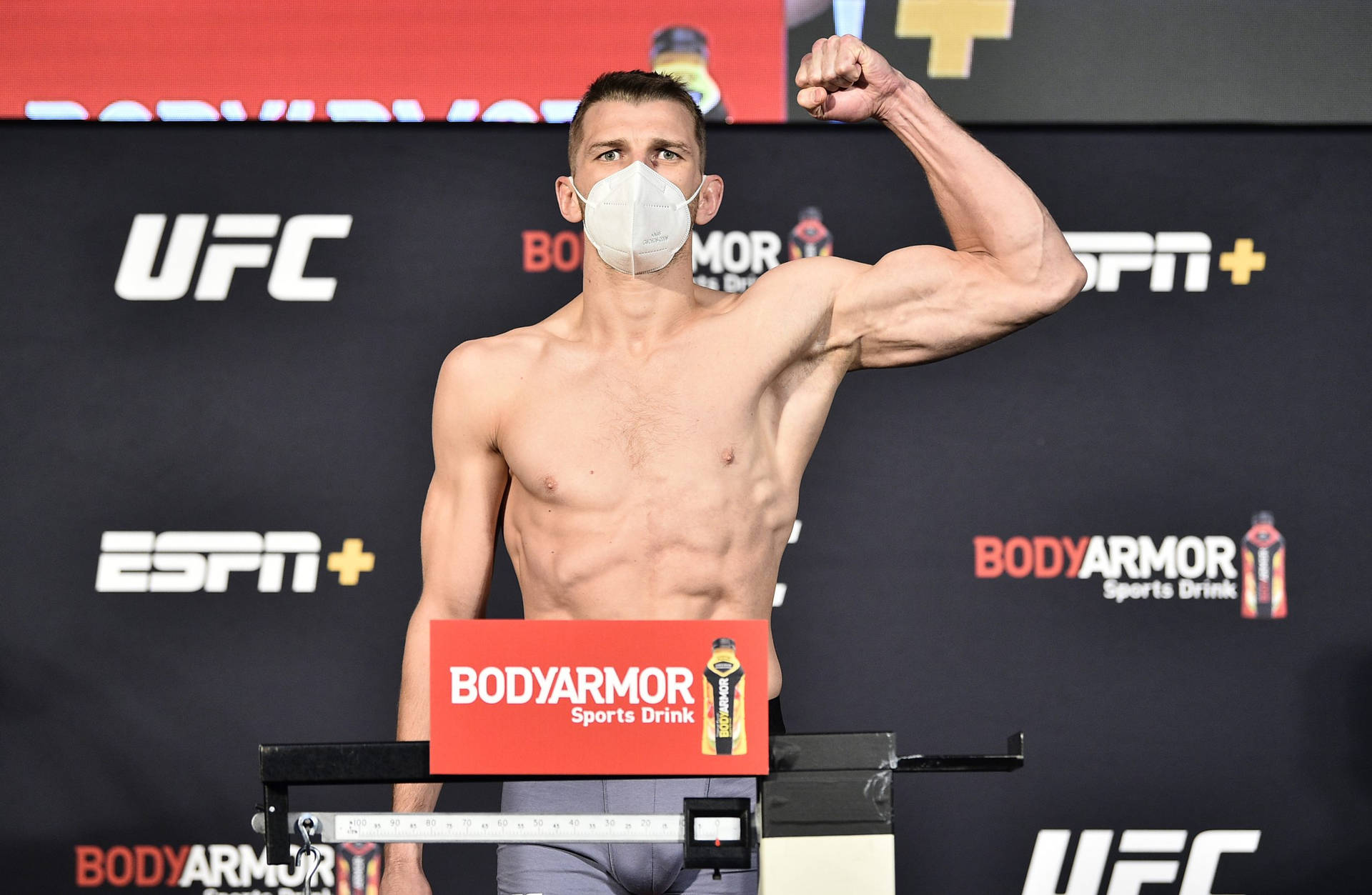 UFC拳手在稱重時戴著口罩展示二頭肌