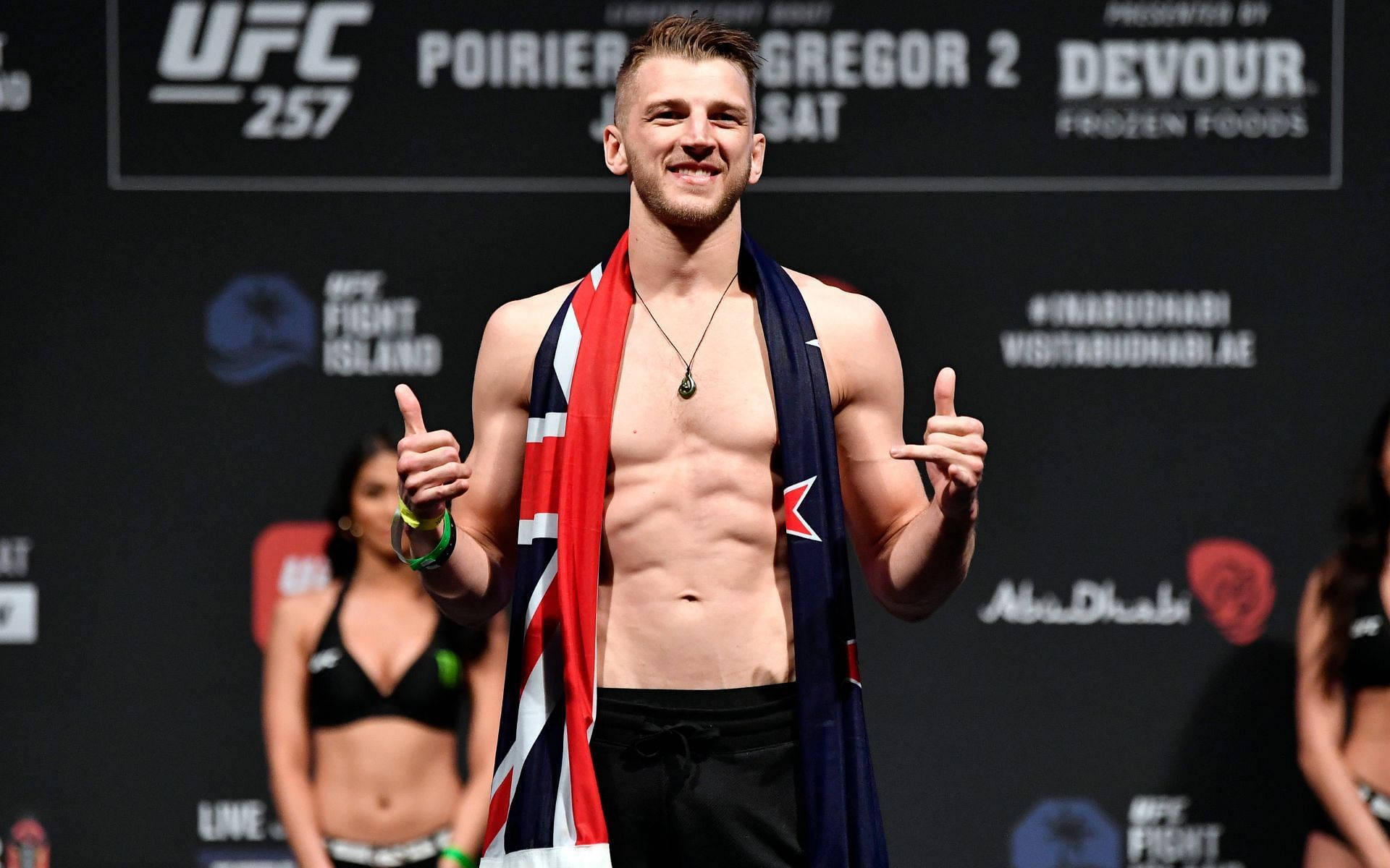 UFC拳手在稱重活動中微笑並披著英國國旗。