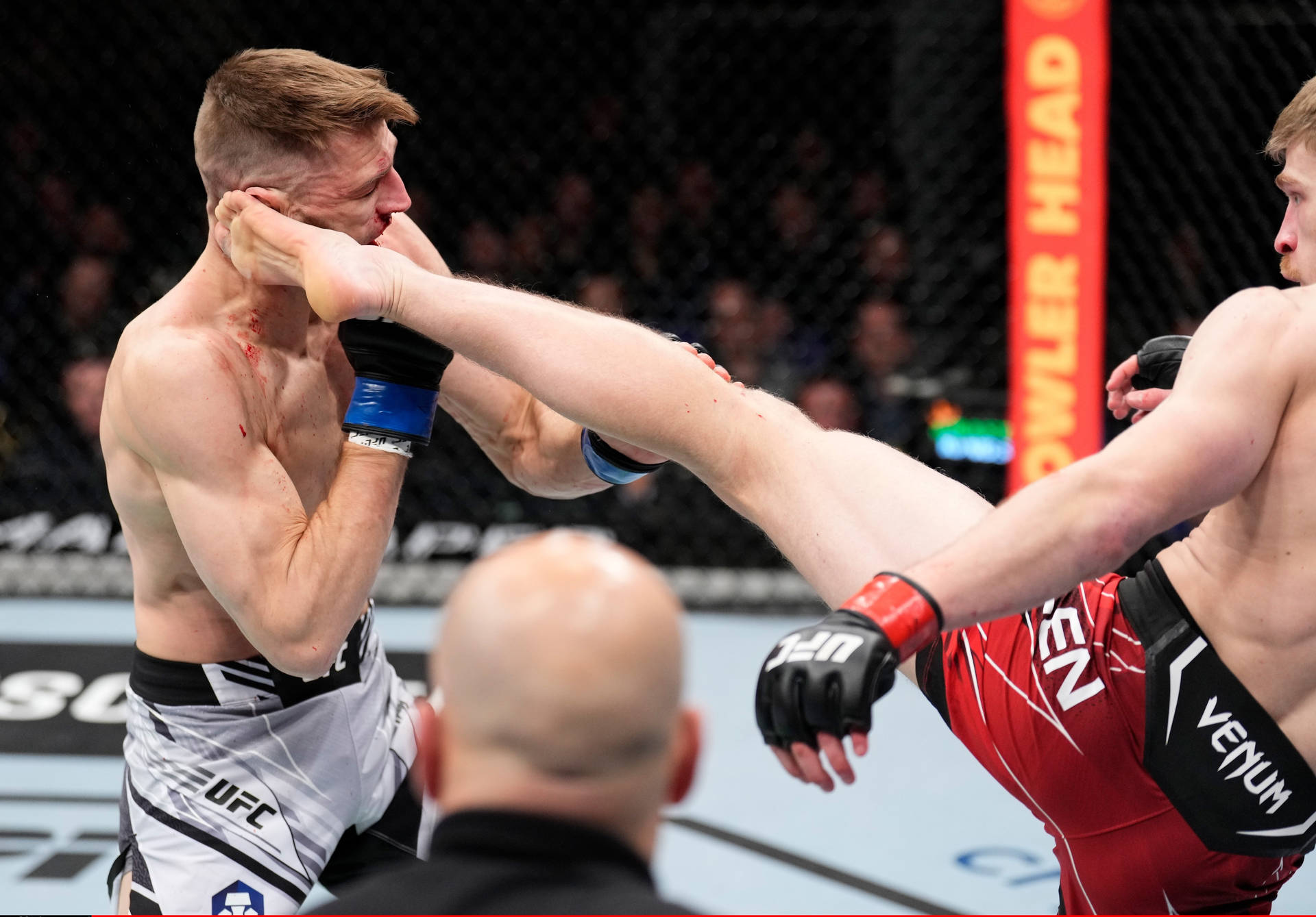 MMA拳手在八角籠中向對手面部踢出高踢