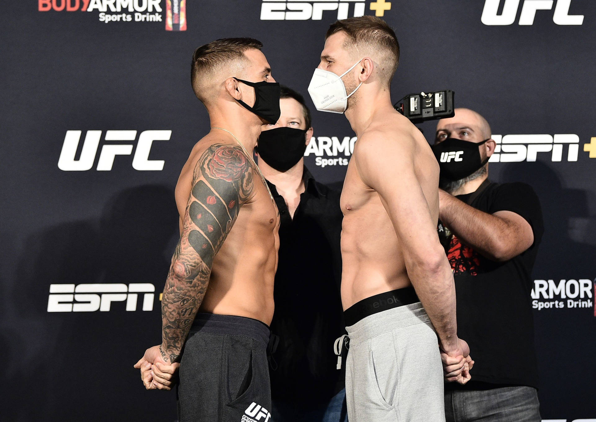 兩名身穿運動服的男性MMA拳手在UFC稱重活動中面對面。