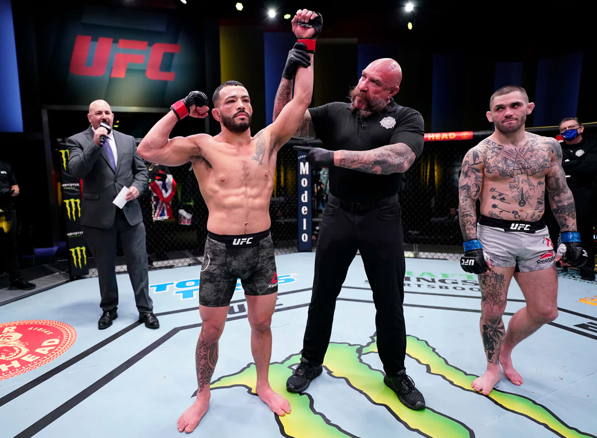 UFC拳手贏得比賽，裁判在八角籠中舉起他的手。