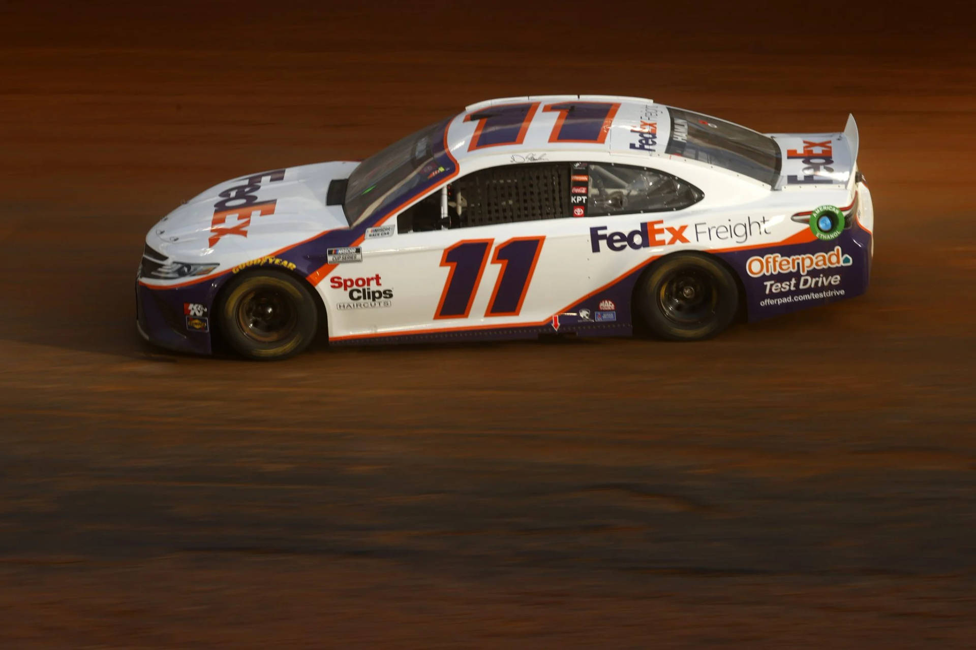 夜間在泥地賽道上疾馳的FedEx Freight賽車