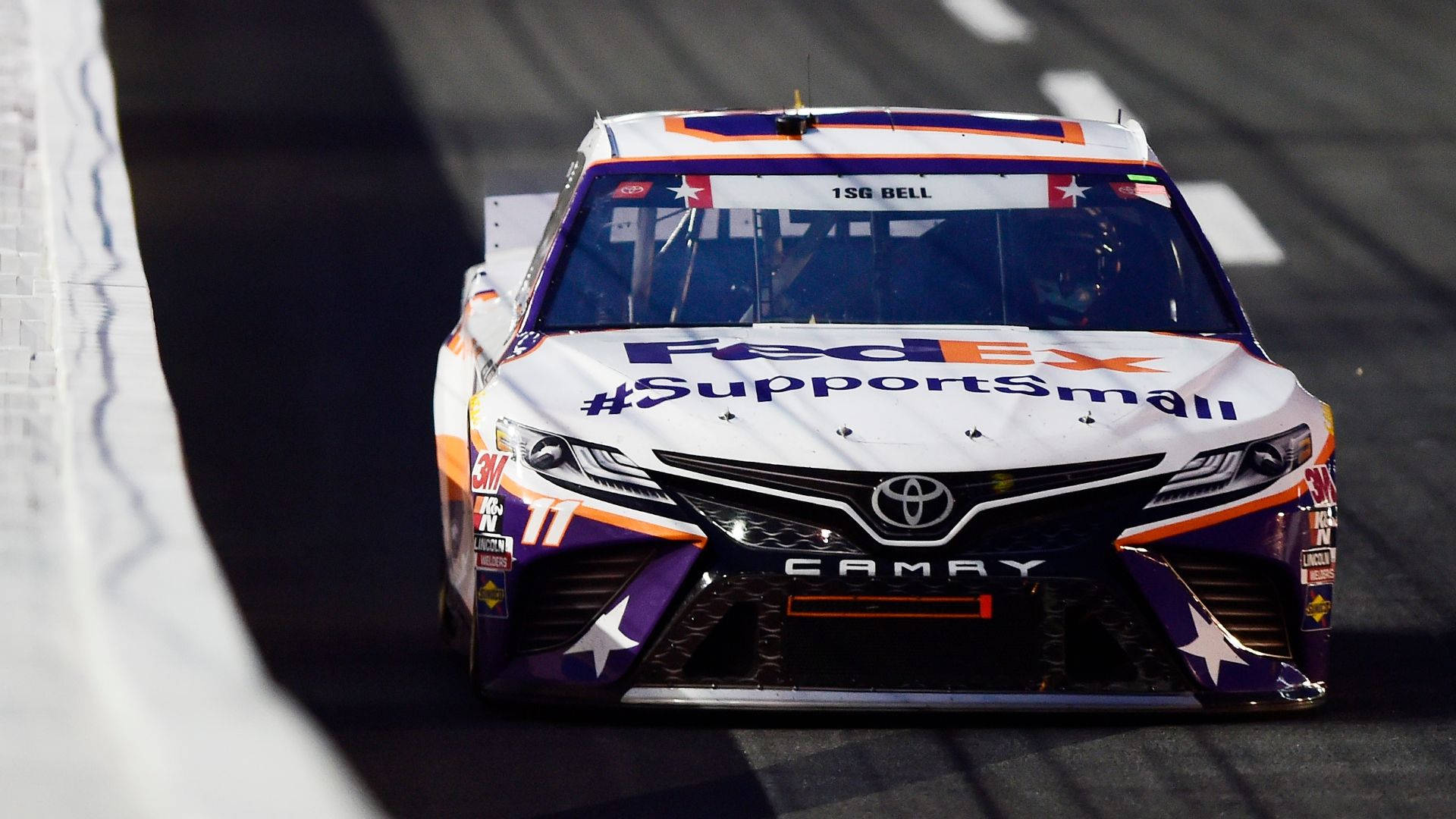 FedEx Toyota Camry賽車在賽道上飛馳，帶有星星貼紙和贊助商標誌。