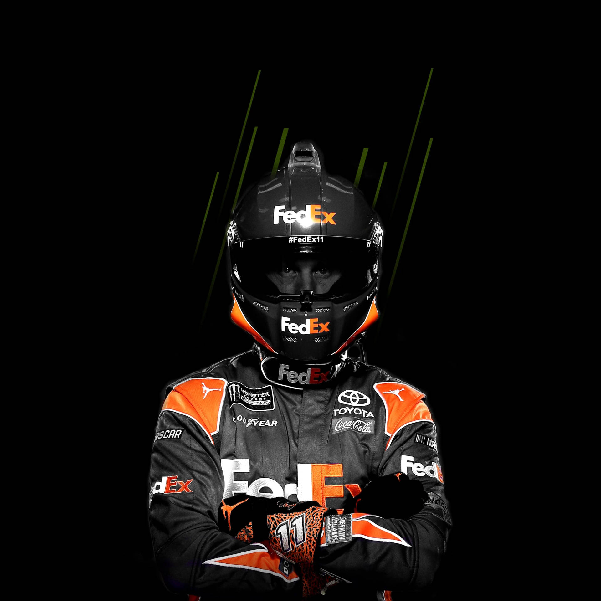 穿著FedEx制服的NASCAR車手在深色背景和綠色條紋中交叉雙臂。
