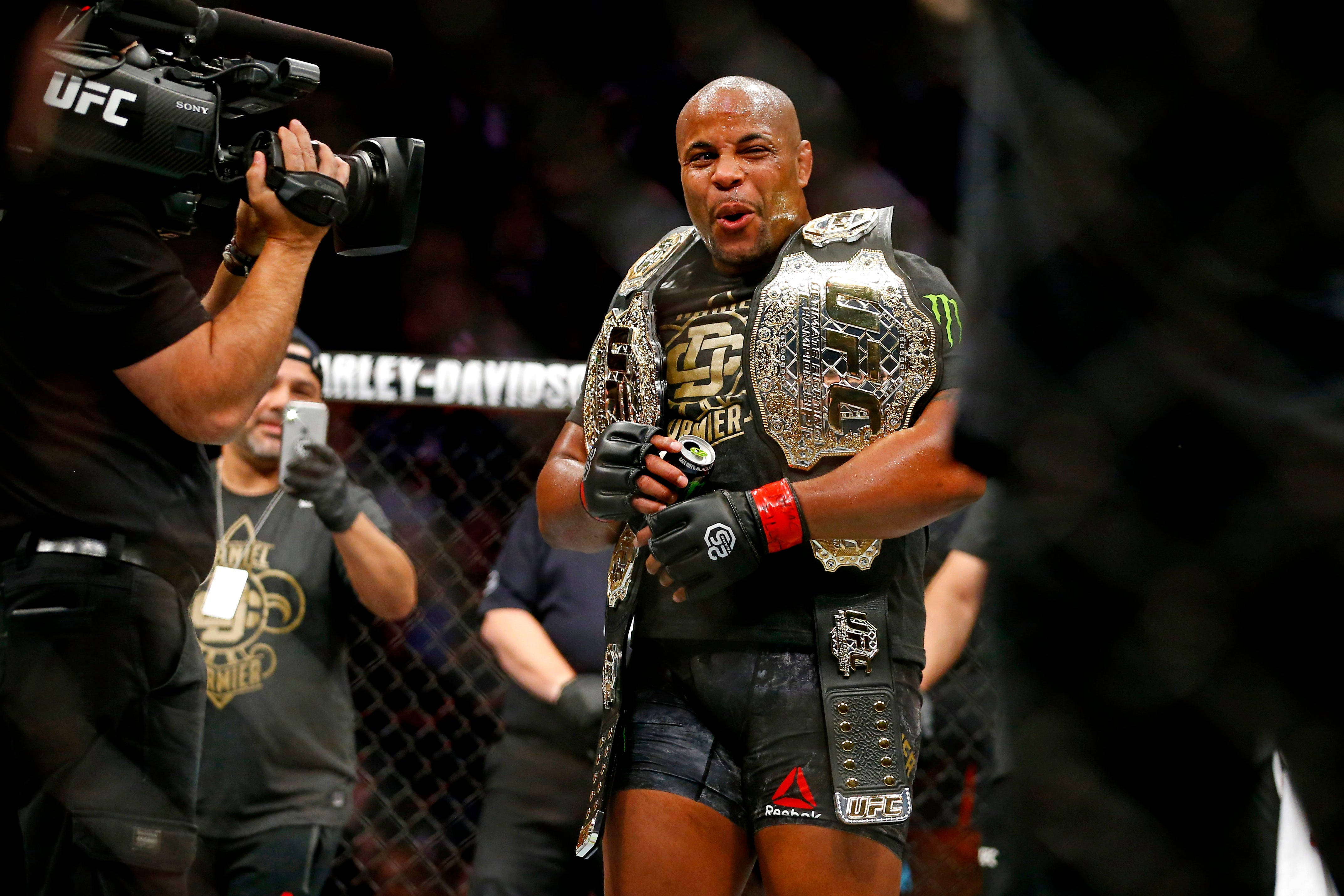 丹尼爾·科爾米爾 UFC 230 活動 壁紙 — 一位勝利的UFC拳手在八角籠內手持冠軍腰帶慶祝勝利。