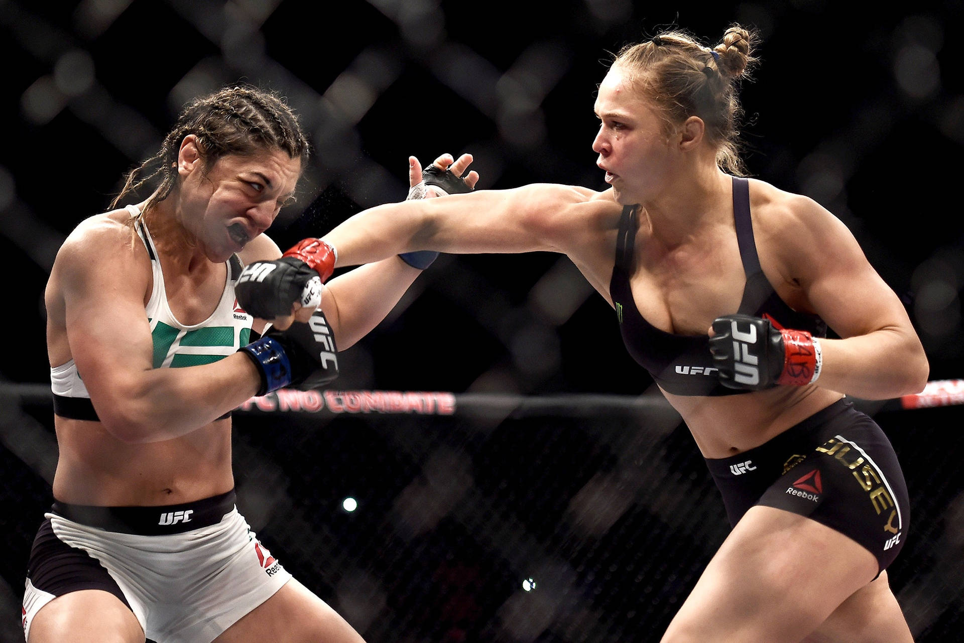 兩名女性MMA拳手在籠中進行高強度比賽。