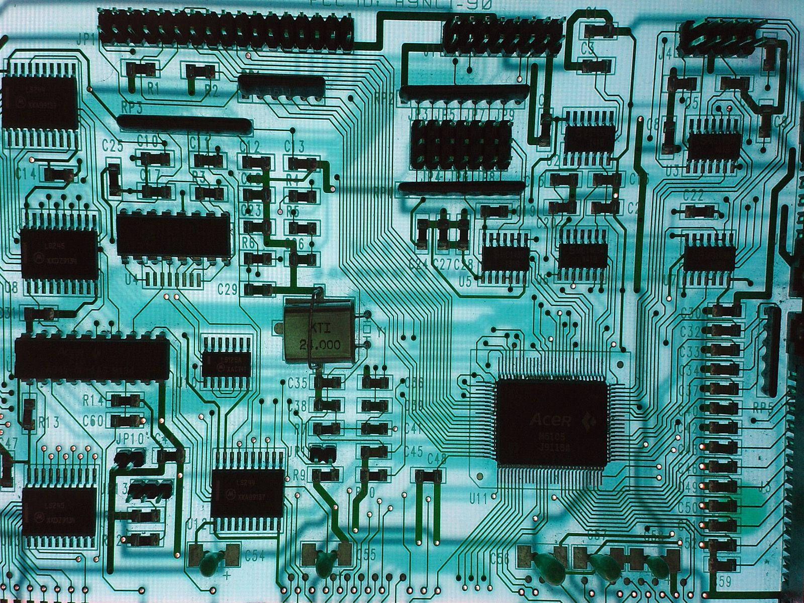 主機板晶片組 壁紙 — 特寫鏡頭：一塊青綠色電路板，在柔和光線下呈現複雜的綠色路徑和黑色集成電路。