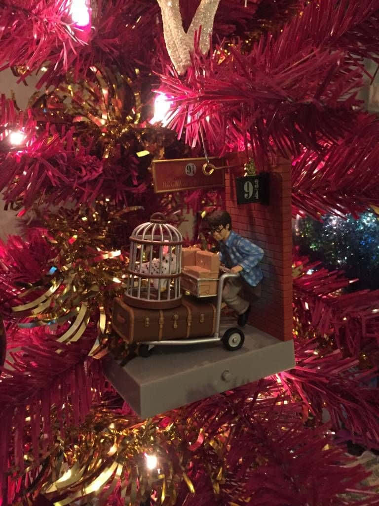 哈利波特裝飾品，在紅金色閃粉樹上帶有手推車和籠子。