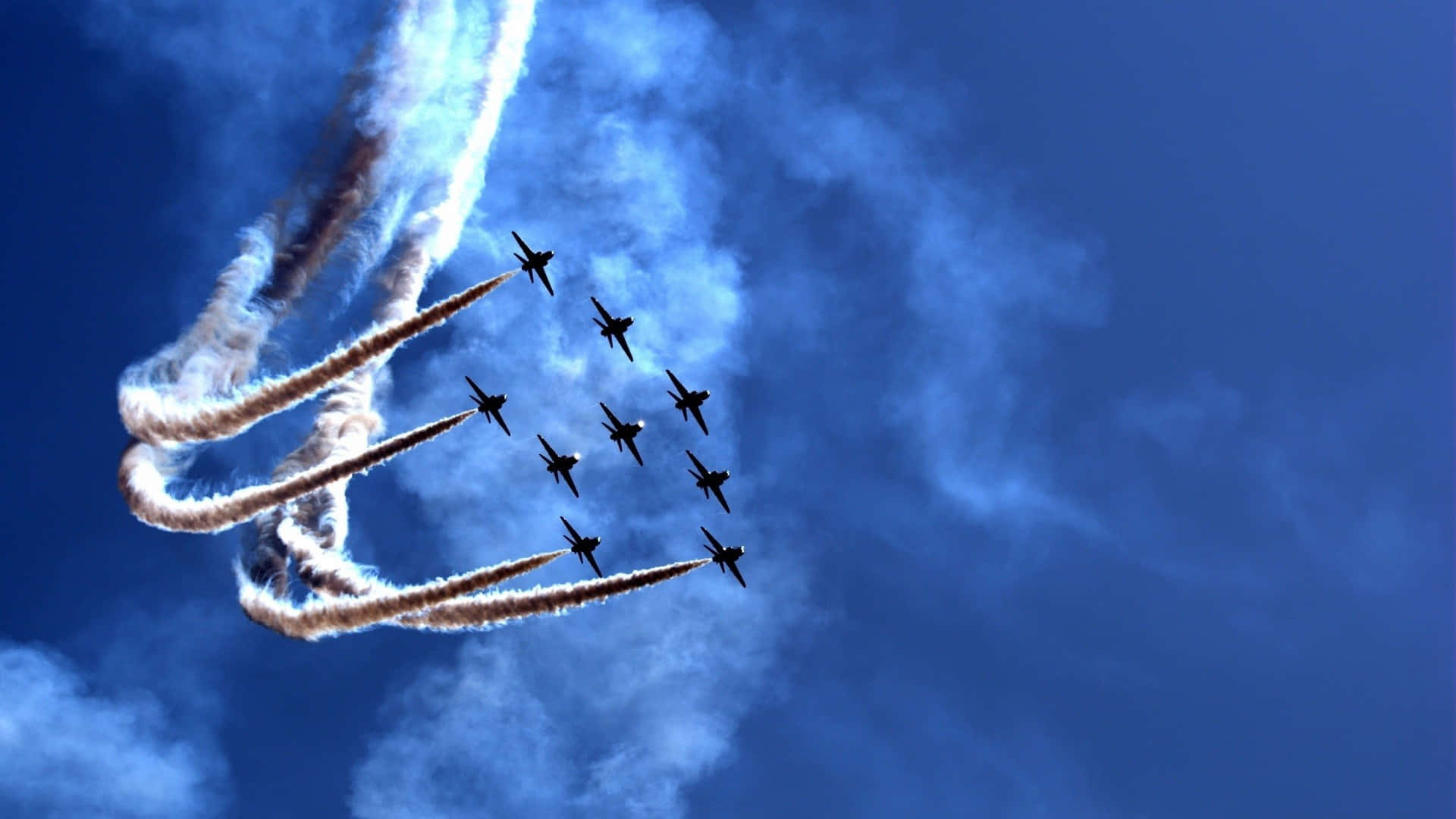 空軍 桌布 壁紙 — 九架戰鬥機在深藍色的天空中緊密編隊飛行，留下濃厚的白色煙霧痕跡。