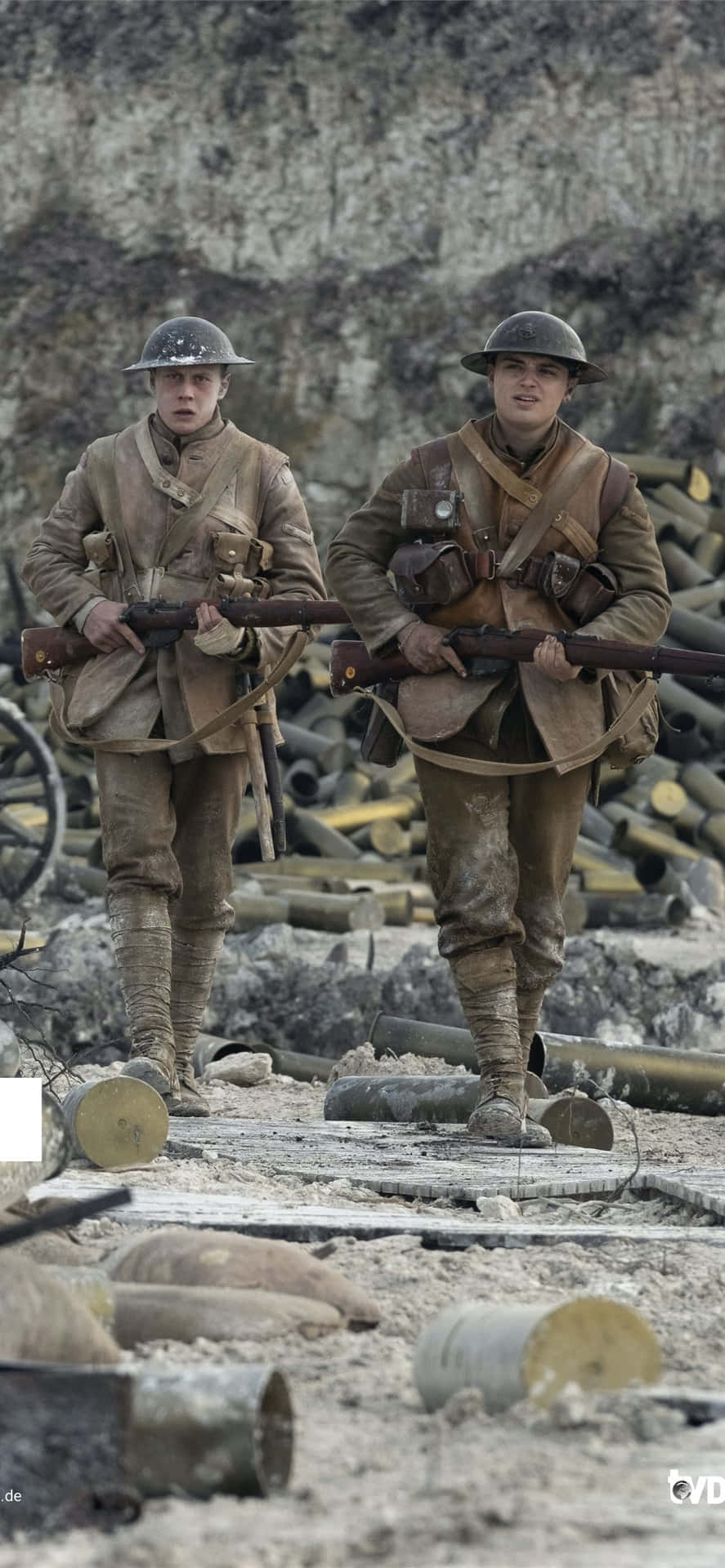 兩名一戰士兵持步槍穿過彈坑遍地的戰場。