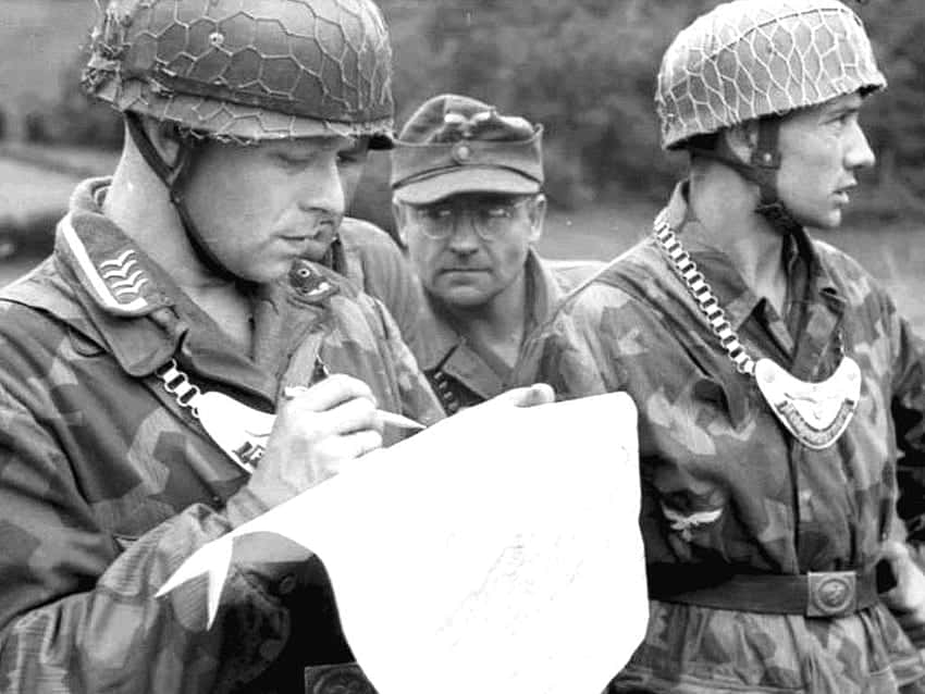 三名身穿軍裝的士兵在戶外檢查地圖。