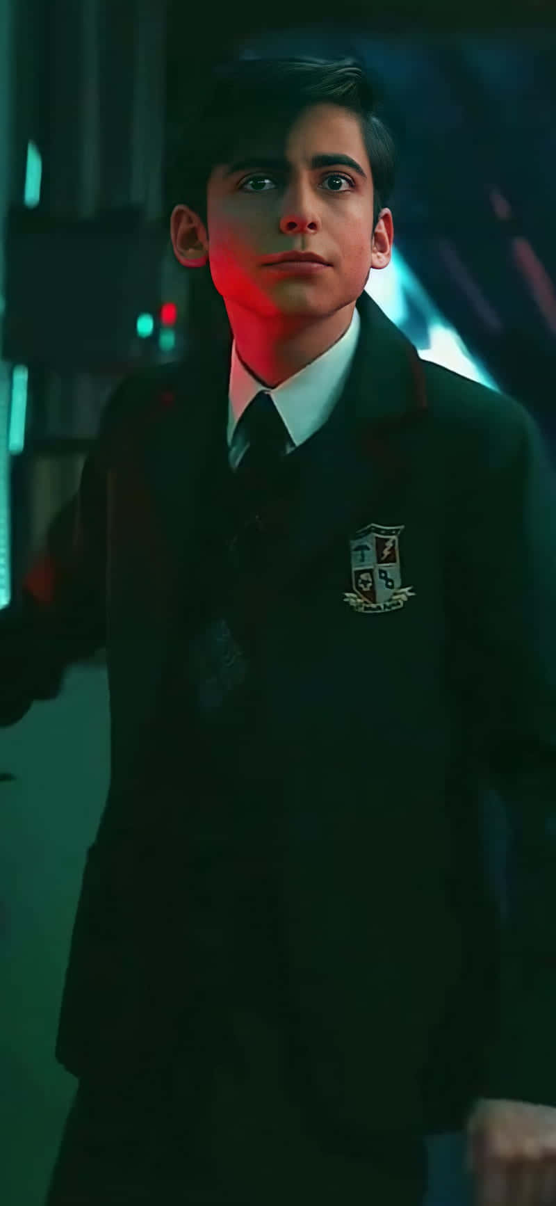 年輕男子身穿校服，在紅色和藍綠色霓虹燈下