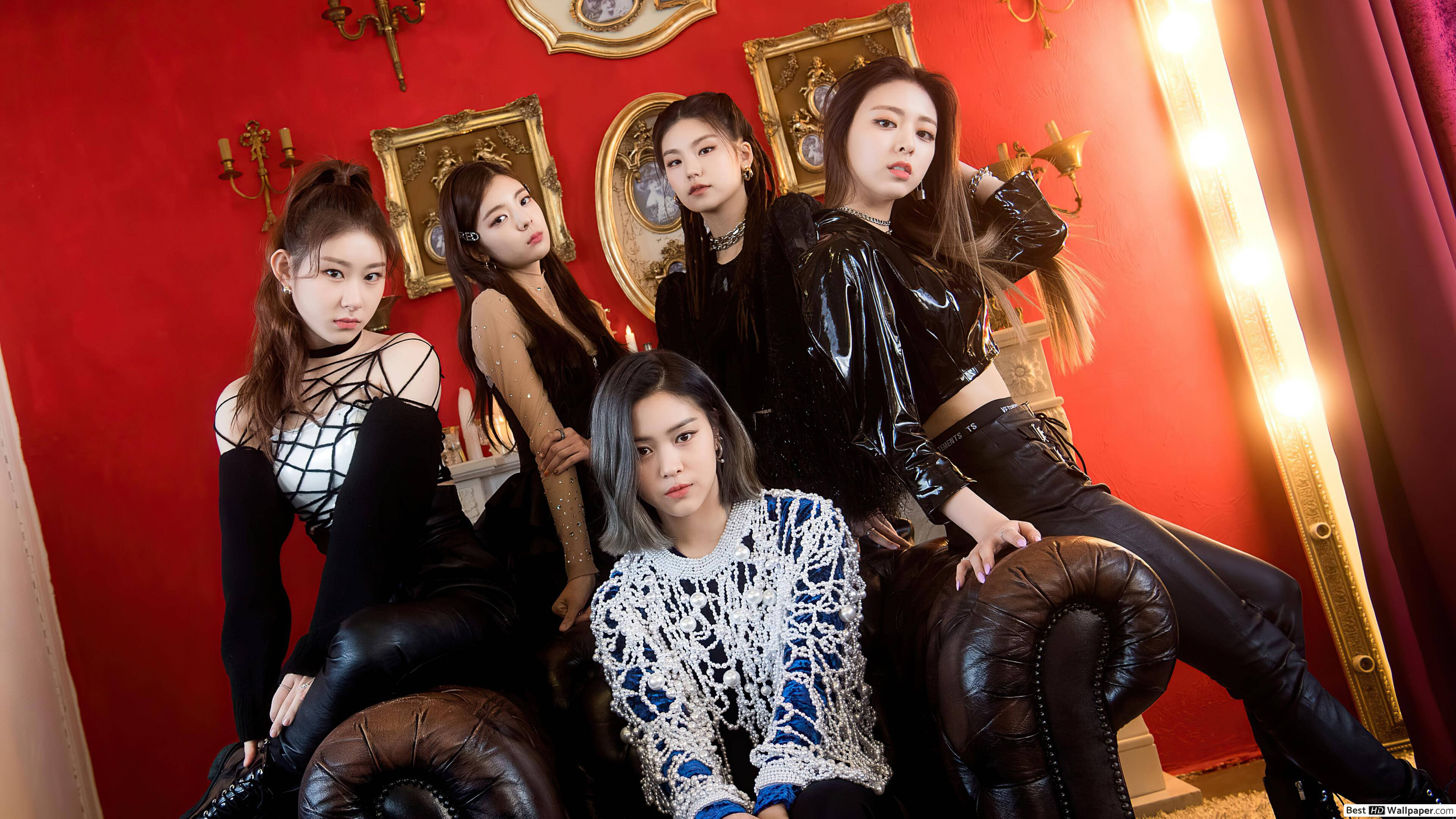 ITZY《WANNABE》MV 壁紙 — 五位時尚女性自信地坐在皮革沙發上，背景是鮮紅色的牆壁，裝飾著金色邊框的鏡子和燭台。
