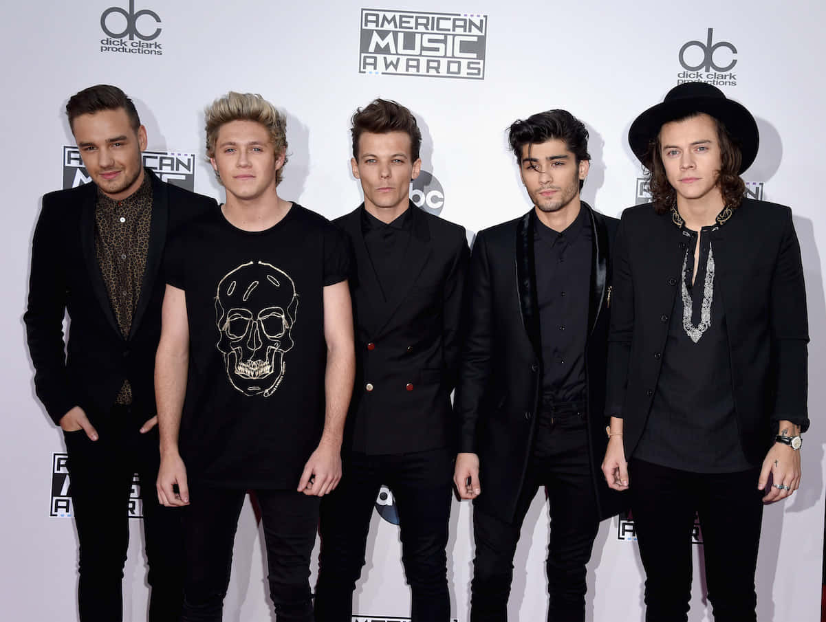 One Direction 桌布 壁紙 — 五位時尚年輕男子身穿黑色服裝，在美國音樂獎的紅地毯上自信地擺姿勢。