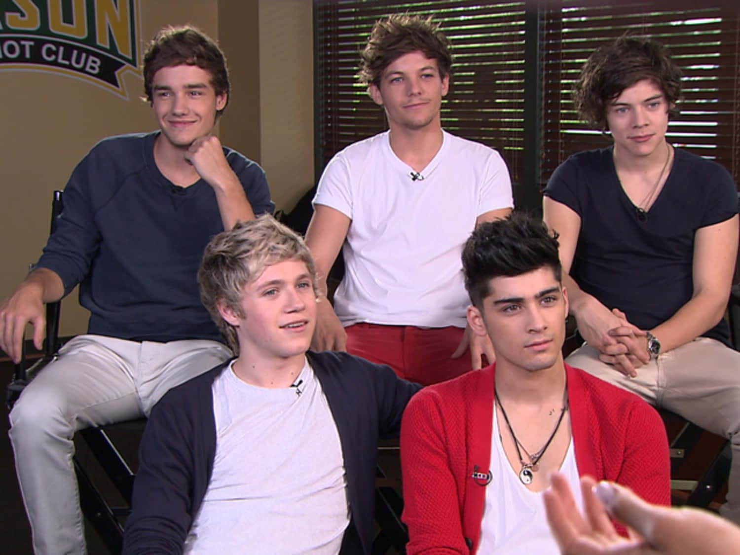 One Direction 桌布 壁紙 — 五位穿著休閒服裝的年輕男性在訪問期間一起坐在錄影廠內。