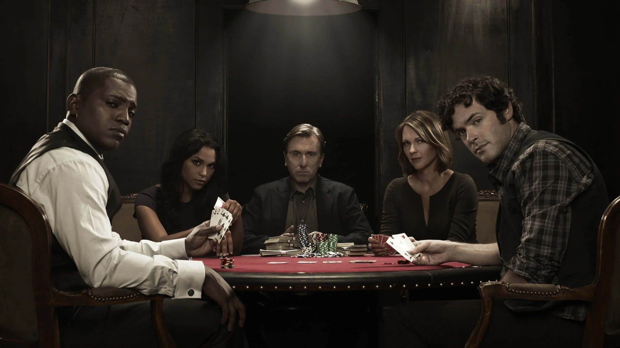 Poker Table 桌布 壁紙 — 五位緊張的撲克玩家在昏暗的木鑲板房間中，在單一頭頂燈光下凝視著一張紅色氈桌。
