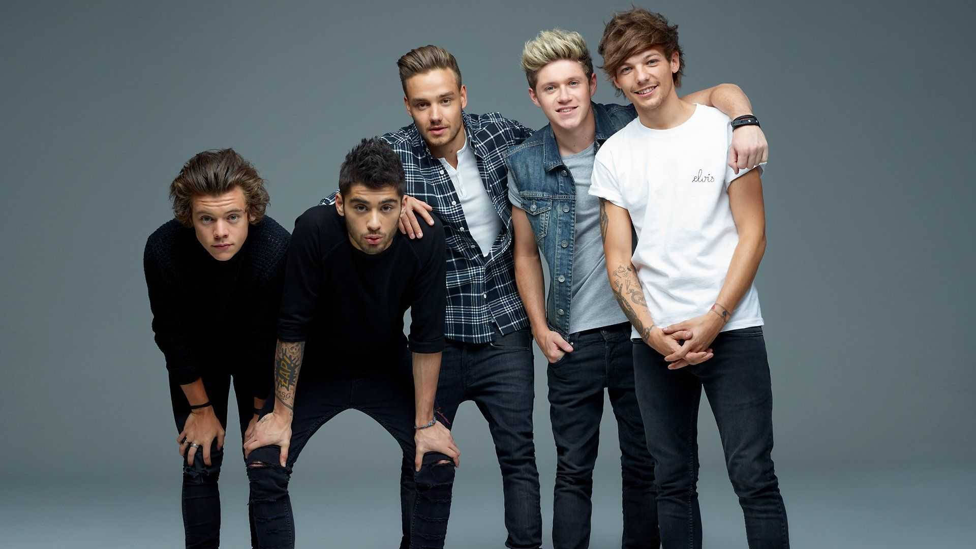 One Direction Aesthetic 桌布 壁紙 — 五位身穿休閒服的年輕男性在純灰色工作室背景前自信地擺出姿勢，表情俏皮。