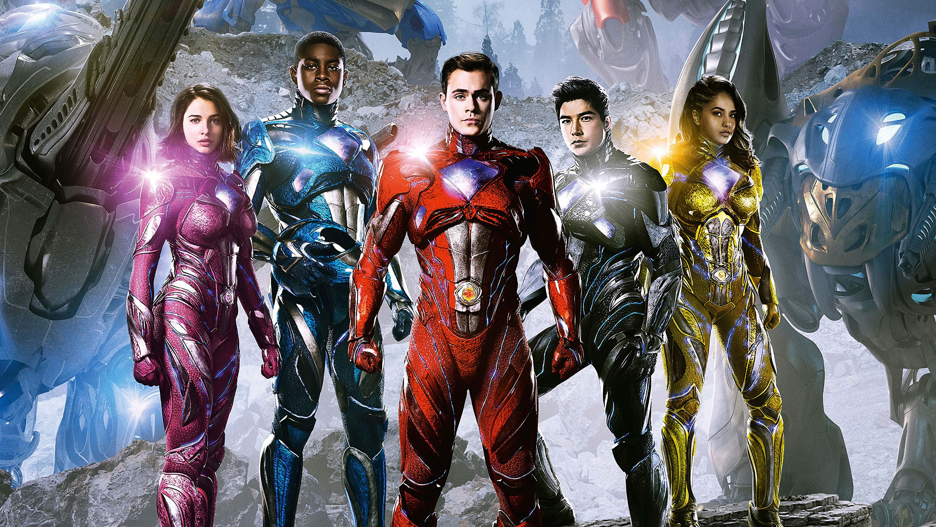 Power Rangers 桌布 壁紙 — 五位身穿發光金屬套裝的超級英雄，在巨型機械戰士和破碎石塊的背景下英勇站立。