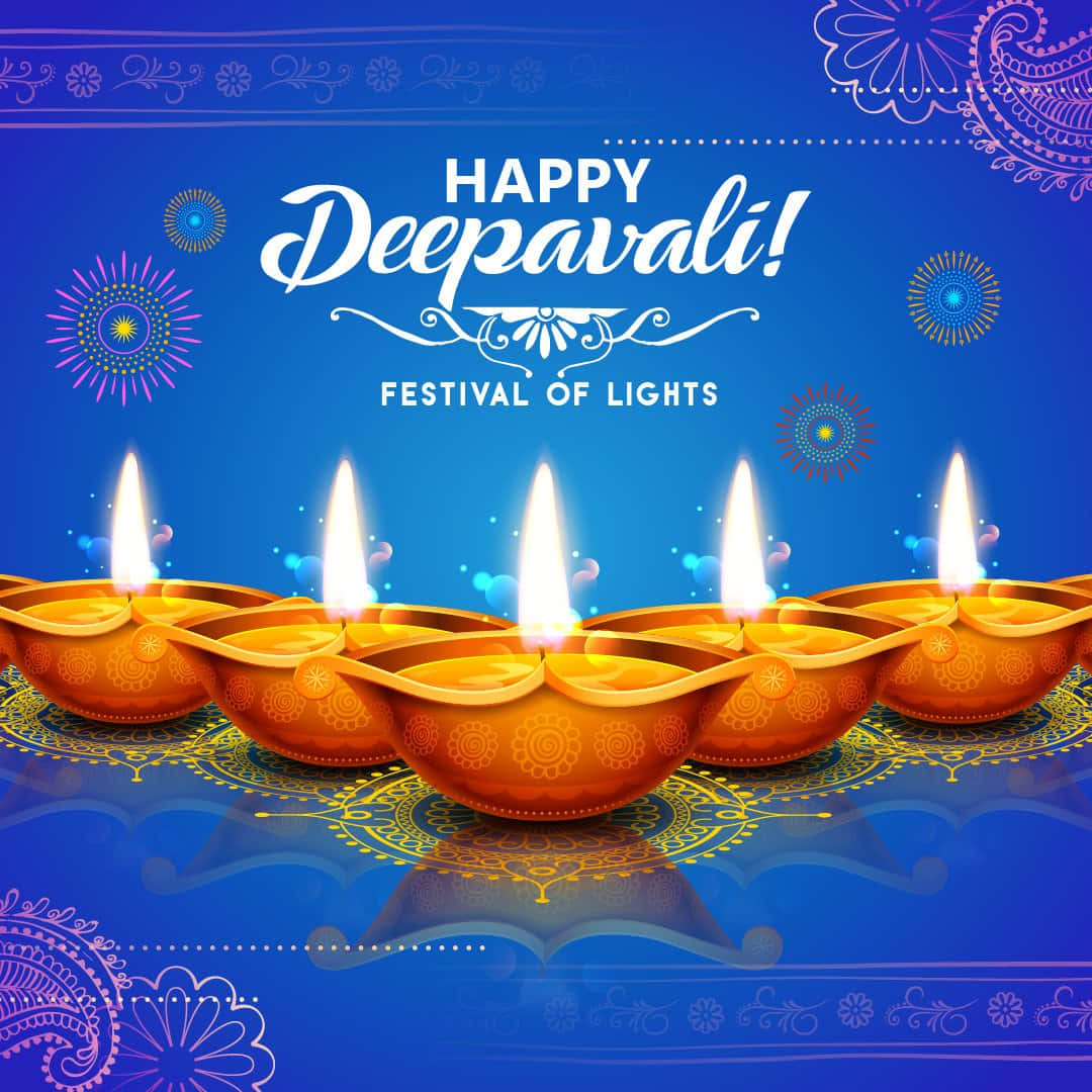 Happy Diwali 桌布 壁紙 — 五個發光的橙色迪亞（油燈）帶有精細圖案，放置在反射藍色表面上，裝飾著節日曼陀羅設計和「Happy Deepavali」文字。
