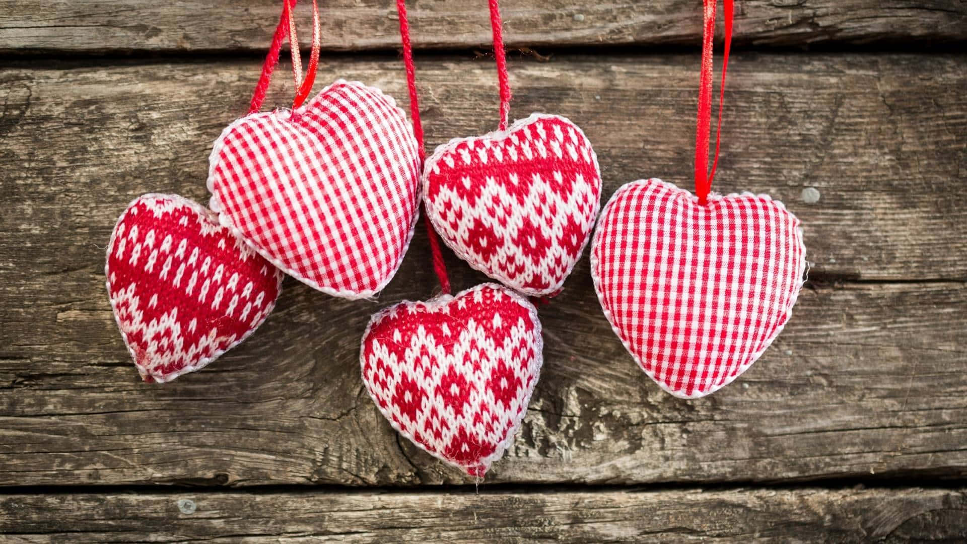 Cute Hearts 桌布 壁紙 — 五個紅白圖案布藝心形以紅繩掛在質樸風化的木質背景上。