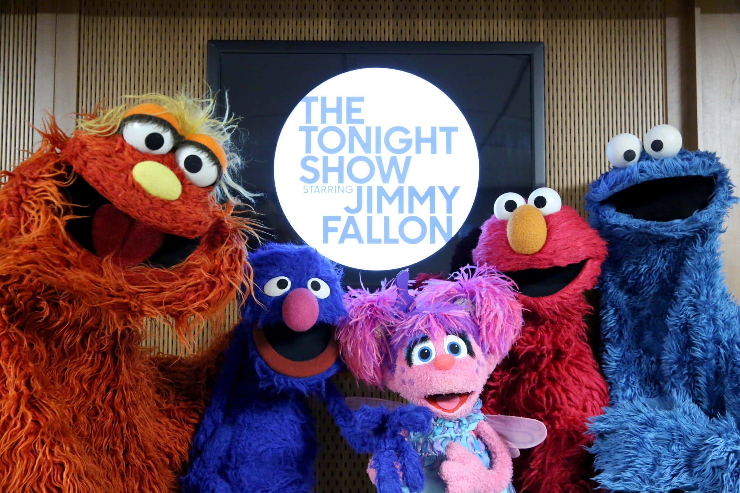 Elmo 桌布 壁紙 — 五個色彩繽紛的芝麻街木偶在 Tonight Show 標誌前愉快地擺姿勢。
