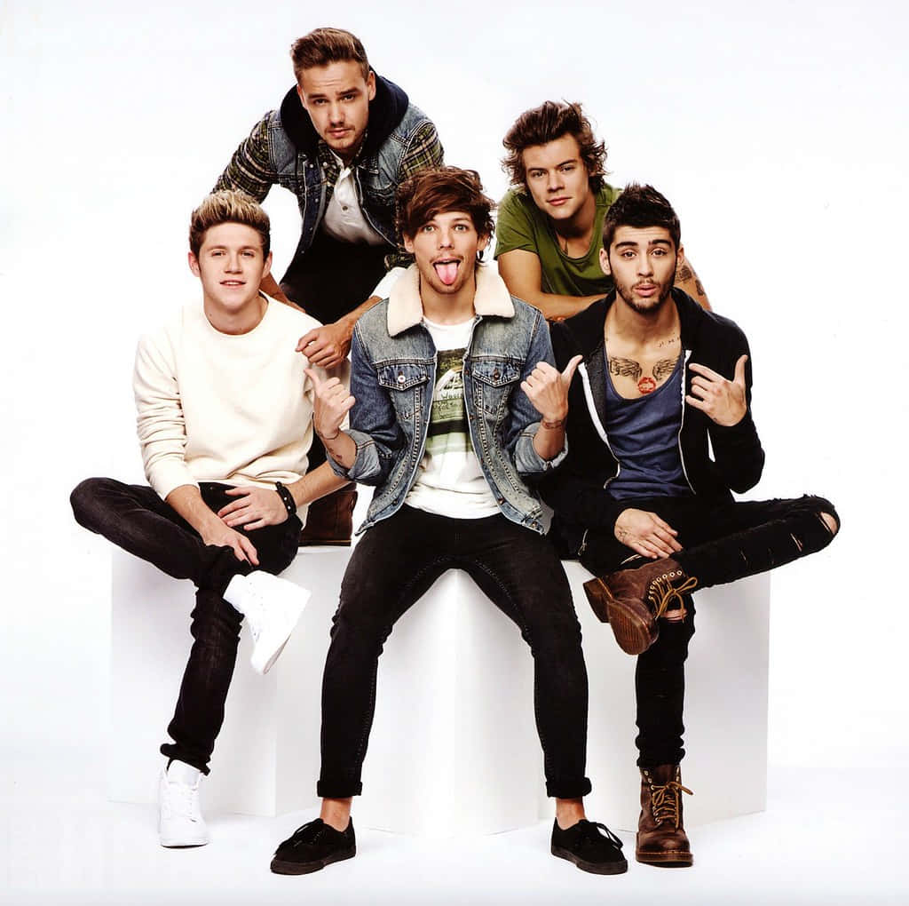 One Direction 桌布 壁紙 — 五名身穿休閒服的年輕男子在白色背景前的白色方塊上頑皮地擺姿勢。