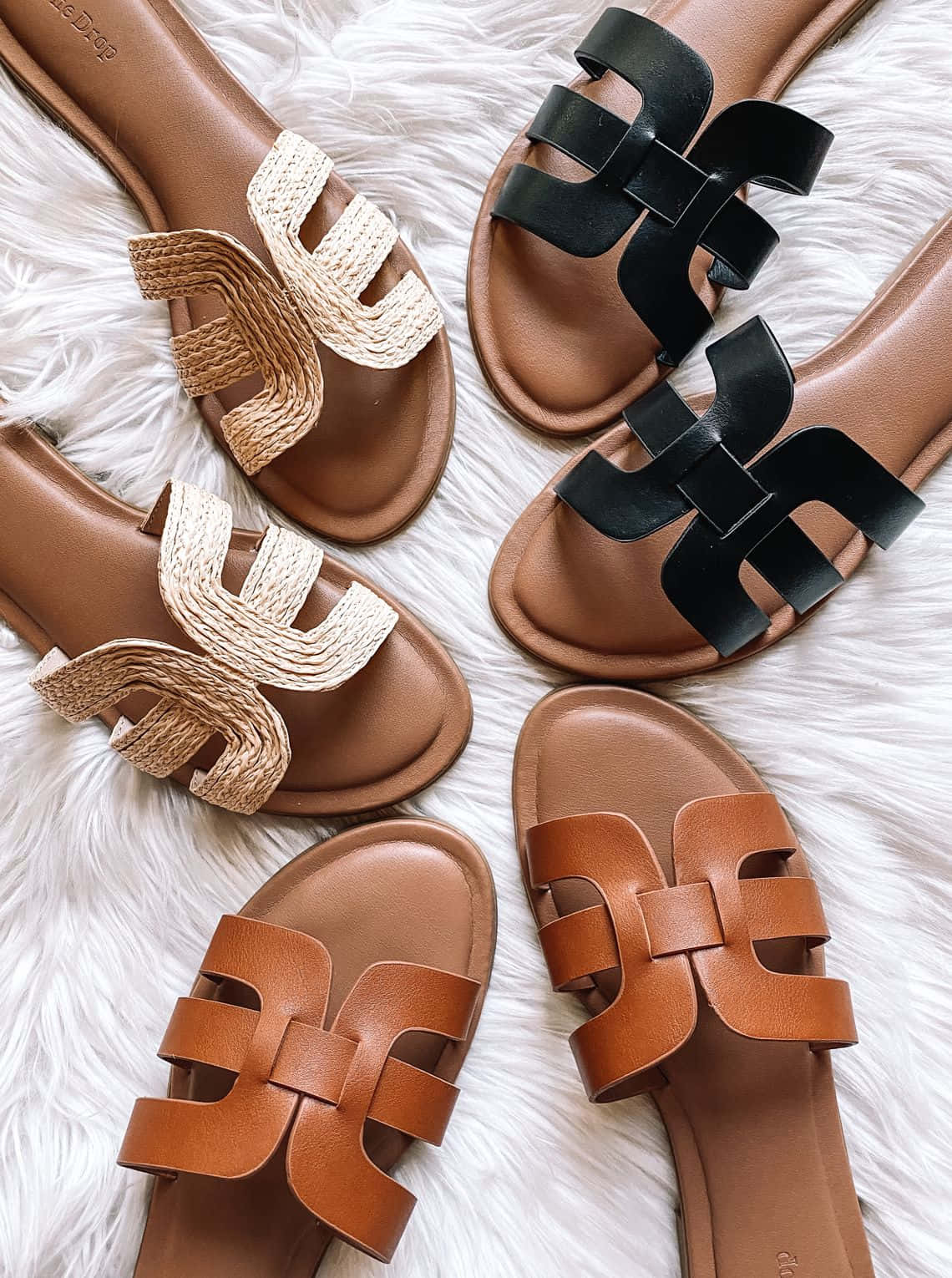 Sandals 桌布 壁紙 — 五對愛馬仕風格涼鞋，採用棕褐色、黑色和棕色皮革及編織帶，排列在蓬鬆的白色地毯上。