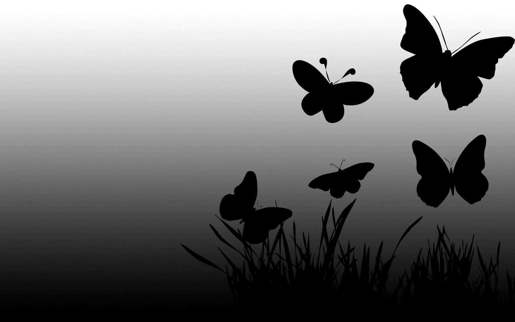 Dark Butterfly 桌布 壁紙 — 五隻黑色蝴蝶剪影在漸變灰色天空的襯托下，在草地上翩翩起舞。