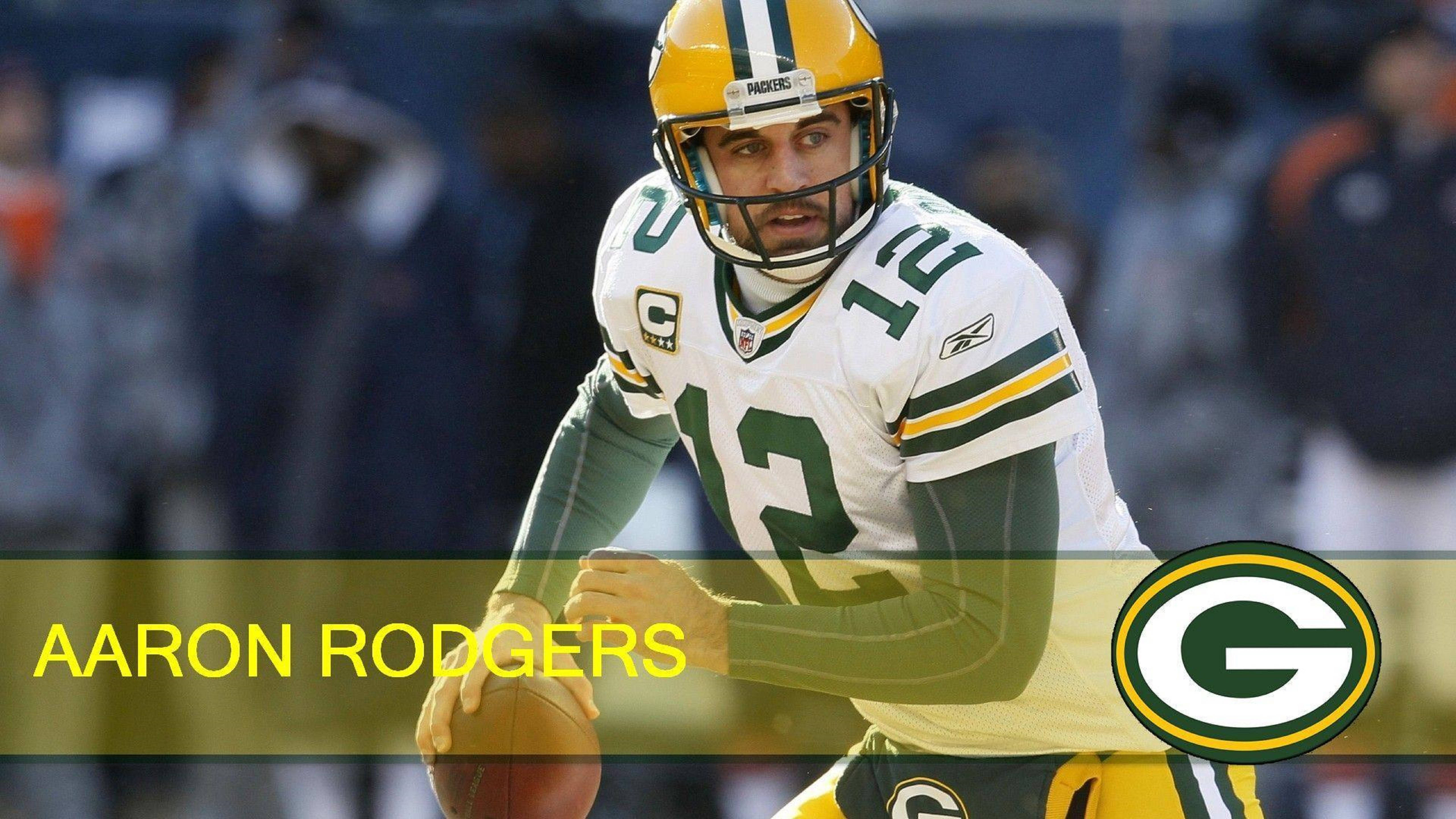 亞倫·羅傑斯 12號四分衛 壁紙 — Aaron Rodgers 身穿綠灣包裝工隊制服，在球場燈光下準備在比賽中投擲橄欖球。