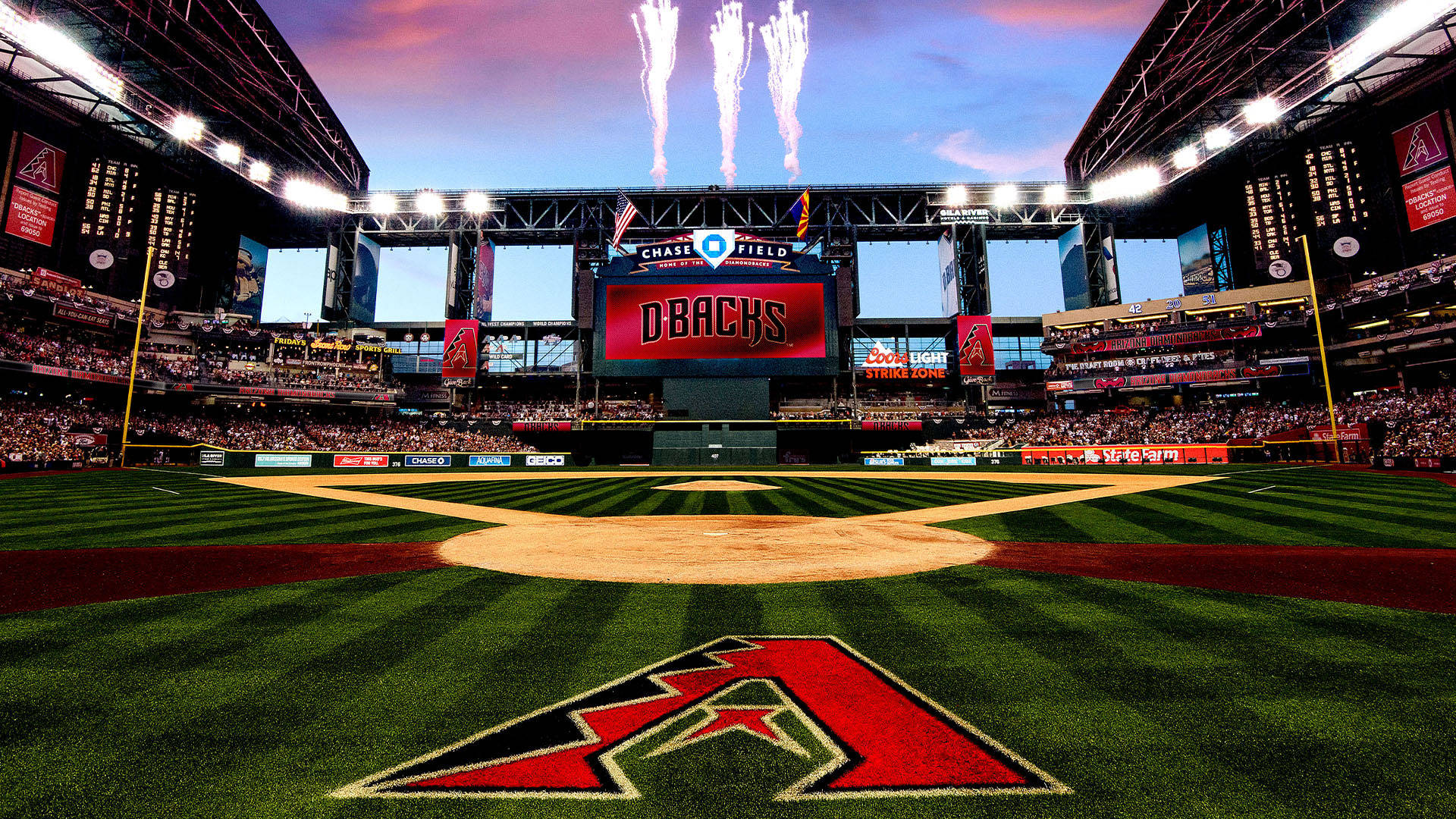 亞利桑那響尾蛇棒球場 壁紙 — 黃昏時分，一個充滿活力的棒球場，Chase Field 記分板上方煙火綻放，看台上坐滿了球迷。
