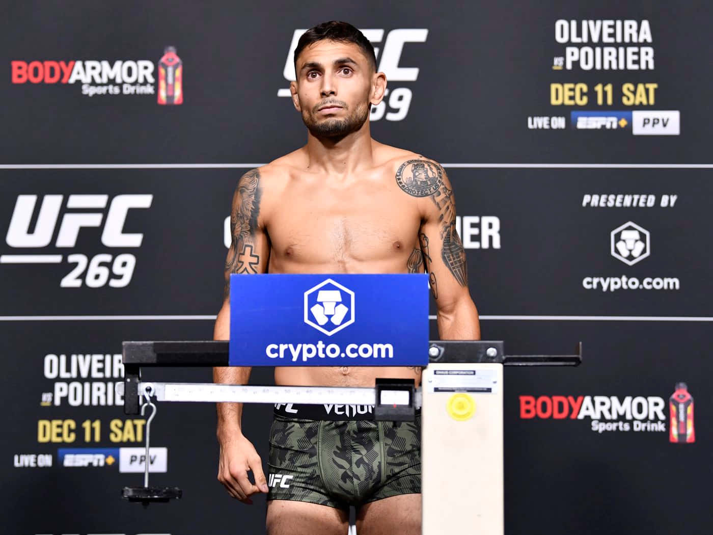 UFC拳手在官方稱重活動中，背景有贊助商標誌。