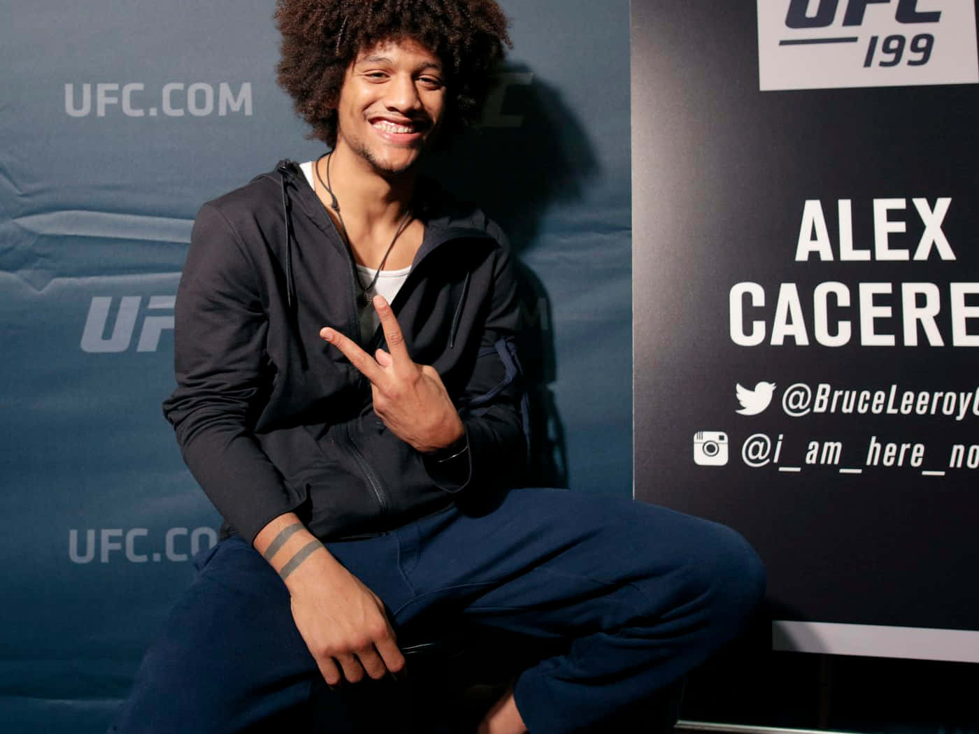 UFC拳手Alex Cacere在活動中微笑並做出和平手勢。