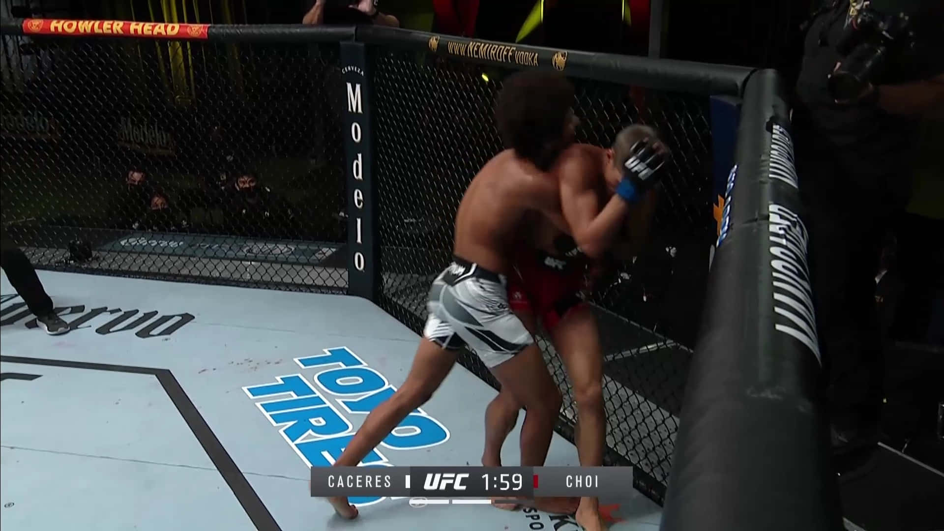 兩名MMA拳手在UFC比賽期間於籠邊圍欄附近纏鬥。