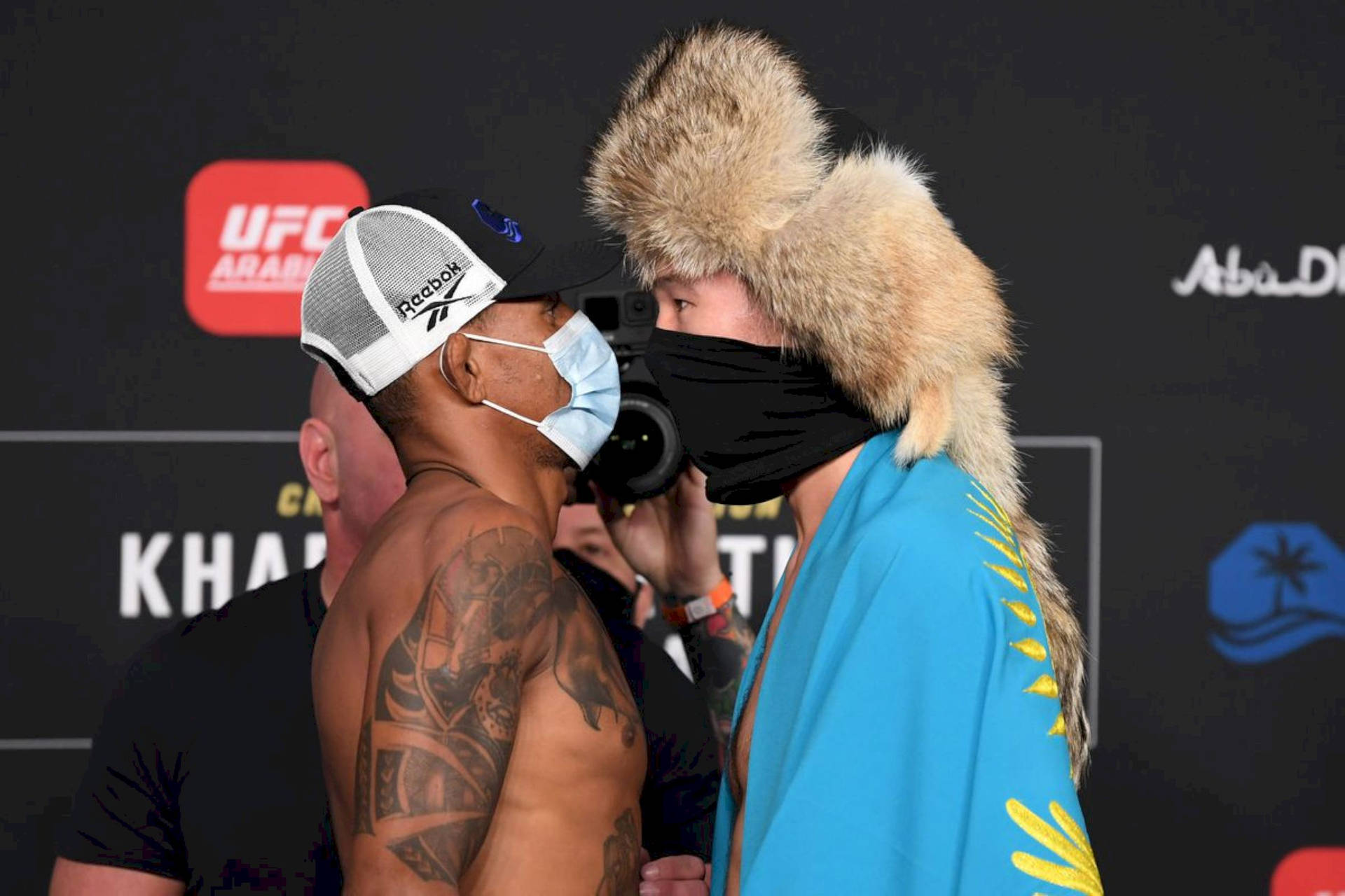 兩位戴著口罩的UFC拳手在稱重時對峙。