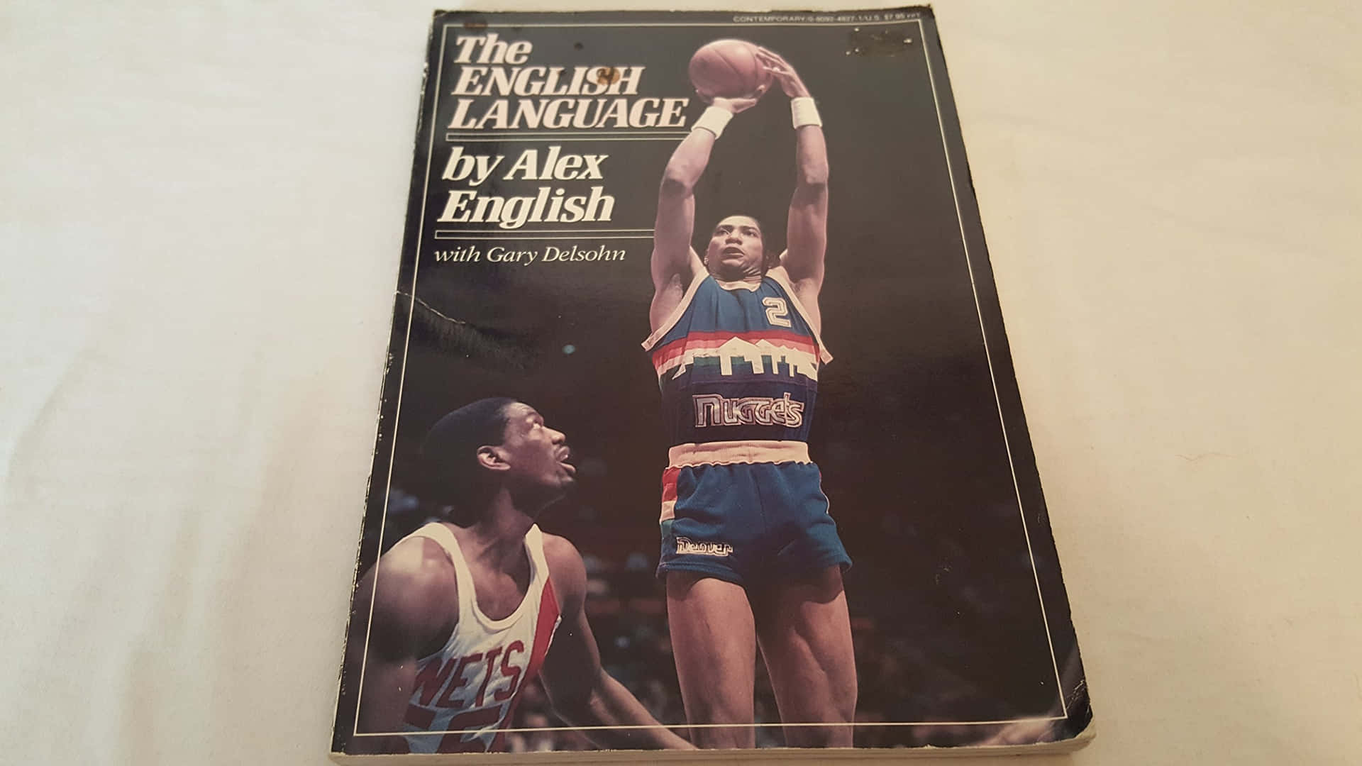 復古籃球書封面，Alex English在防守球員上方投籃。