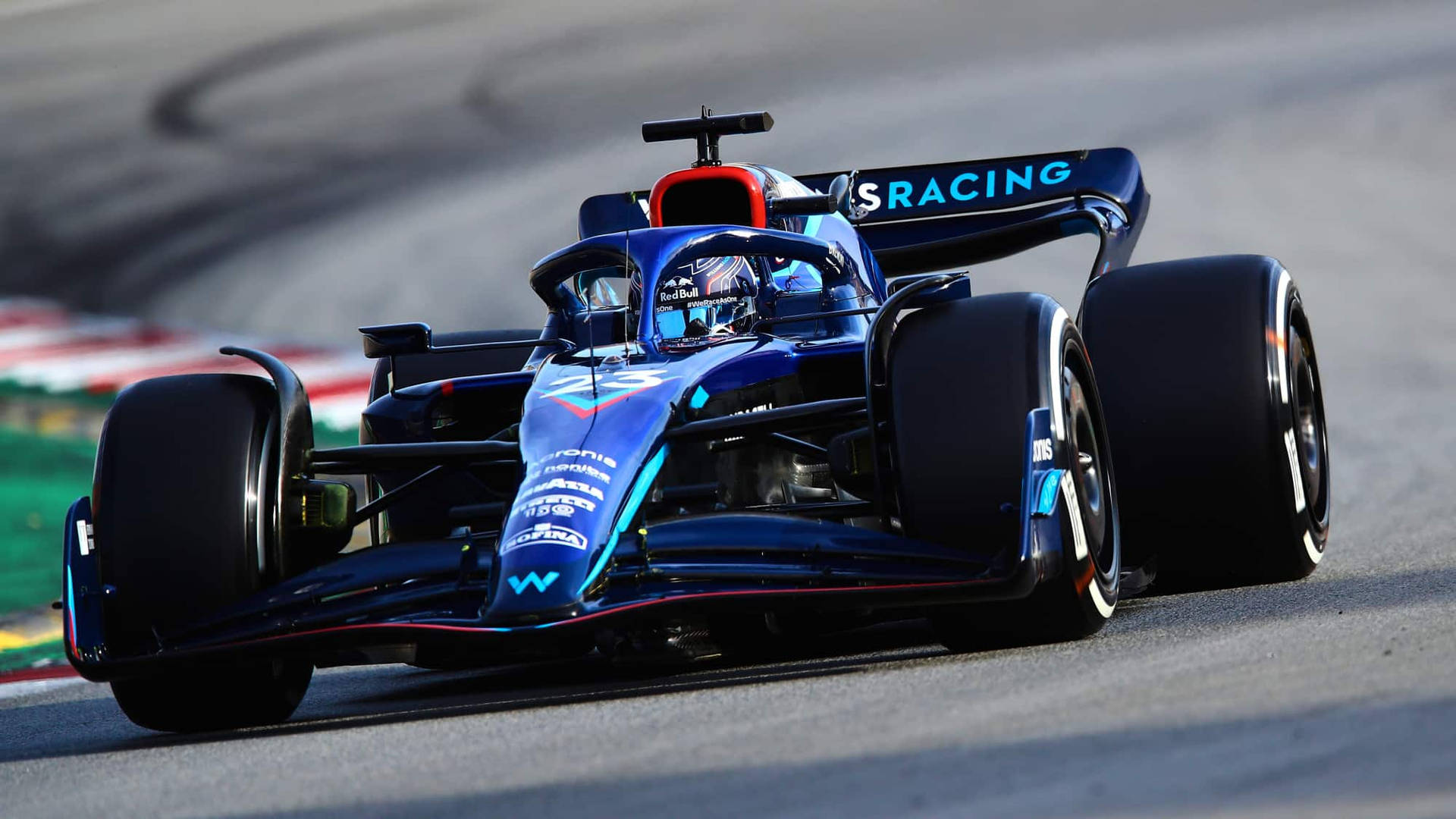 藍色 Formula E 賽車在瀝青賽道上飛馳，賽道設有紅色和白色路緣石。