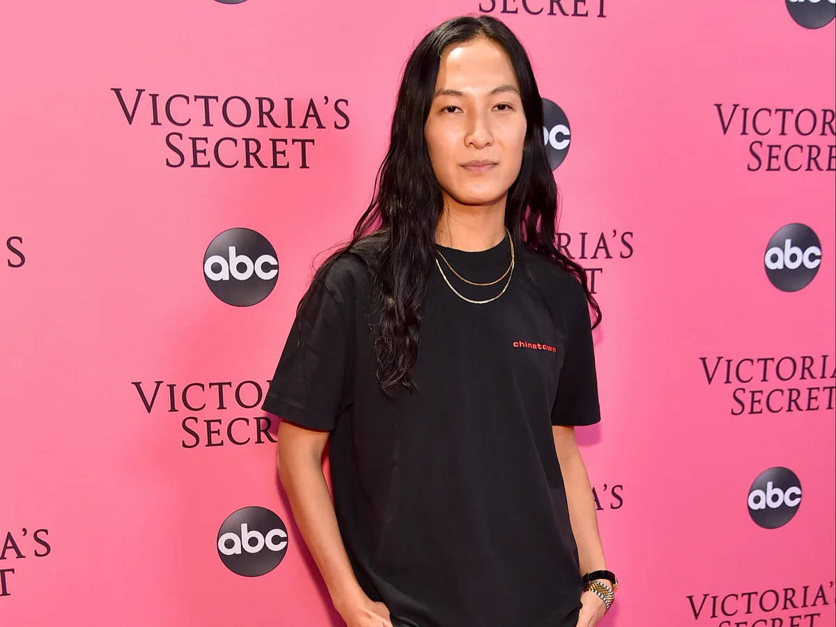 在Victoria's Secret活動中身穿黑色T恤和金色項鍊的人。