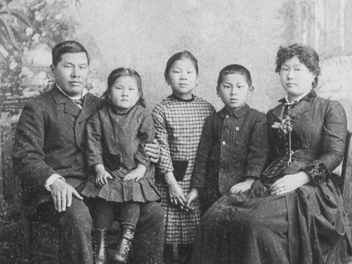 亞洲家庭與瑪麗·泰普 壁紙 — 一張復古棕褐色調的家庭肖像，五個人正式坐在繪有花卉元素的背景前。