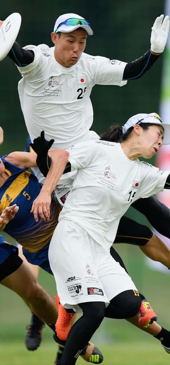 亞洲運動員穿白裝在Android Ultimate Frisbee背景中競技 壁紙 — 兩名身穿白色球衣的運動員在激烈的終極飛盤比賽中動態跳躍接住飛行的飛盤。