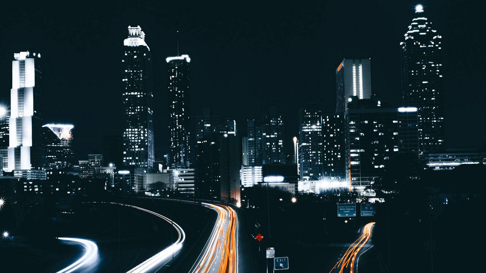 亞特蘭大夜景 壁紙 — 充滿活力的夜景城市景觀，閃爍的摩天大樓和蜿蜒高速公路上的車流光跡。