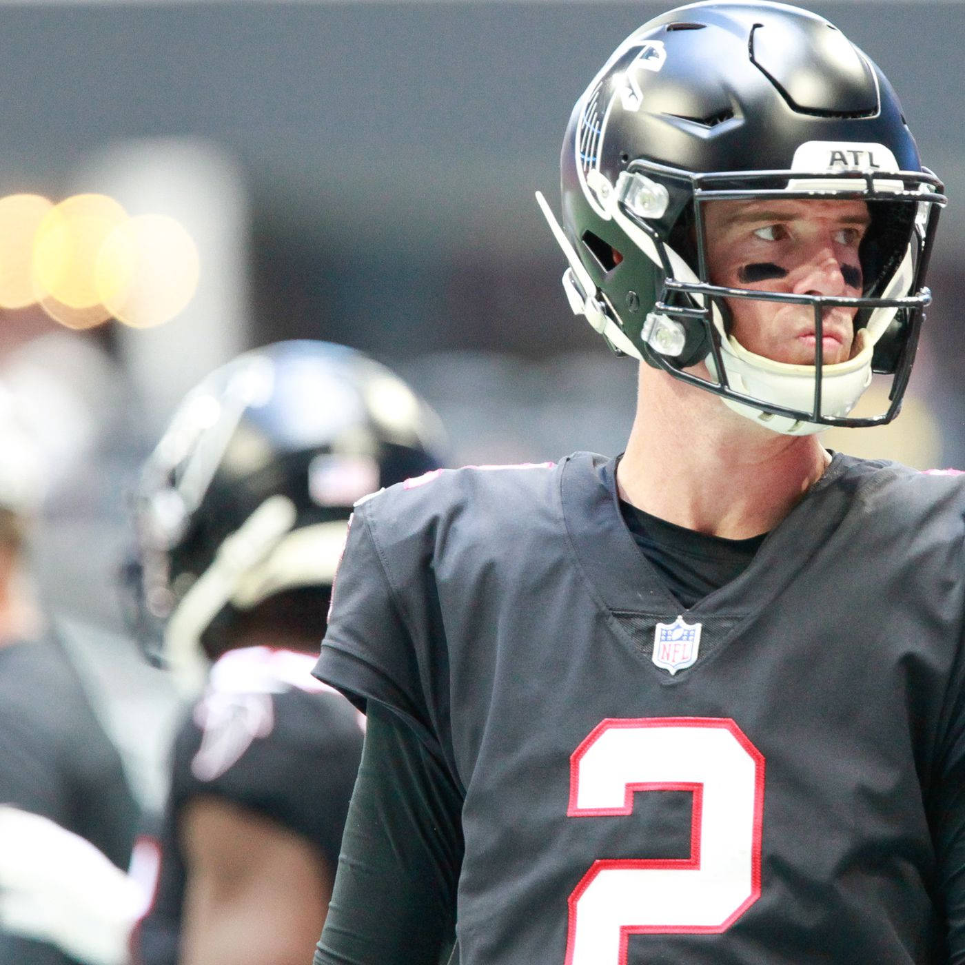 Matt Ryan 桌布 壁紙 — 亞特蘭大獵鷹美式足球員戴頭盔穿2號球衣在模糊球場上的特寫。