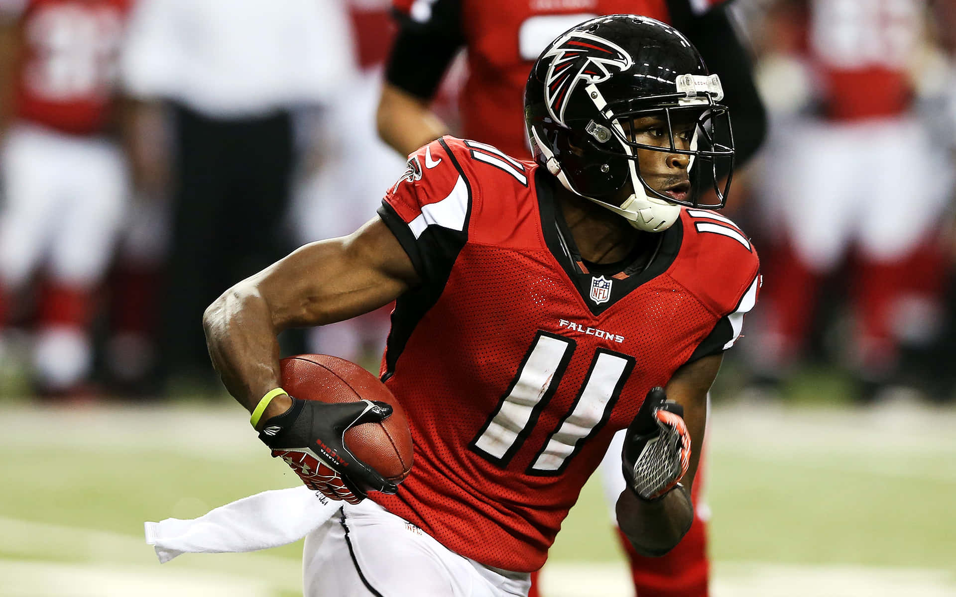 比賽期間身穿紅色 Falcons 制服帶球奔跑的足球運動員。