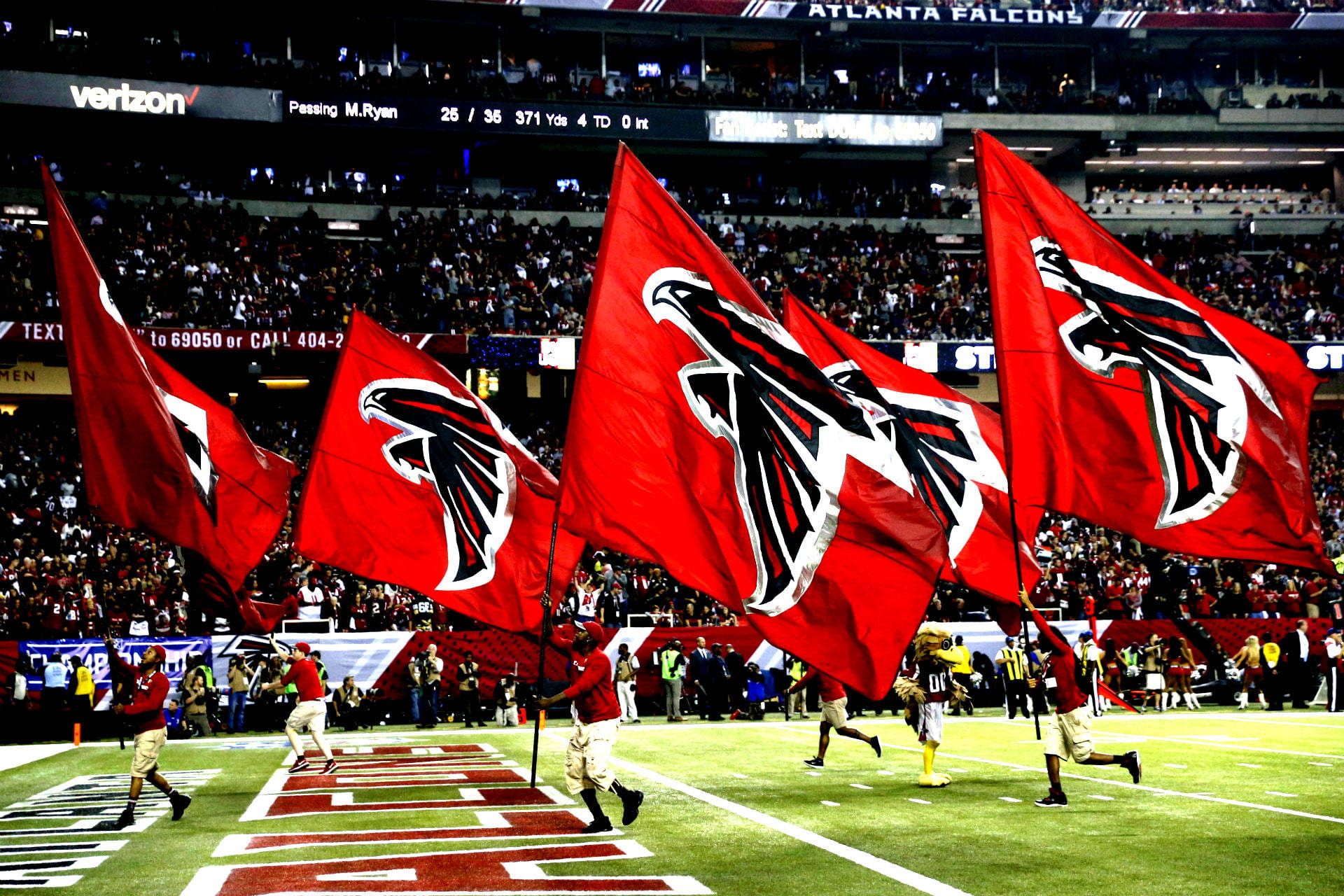 Falcons 足球隊旗幟在夜間比賽中被球員在場上揮舞。