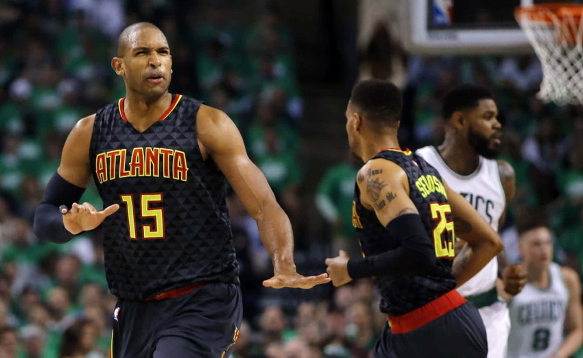 Al Horford 桌布 壁紙 — 亞特蘭大鷹隊15號球員在籃球比賽中與隊友和對手激烈地做手勢。